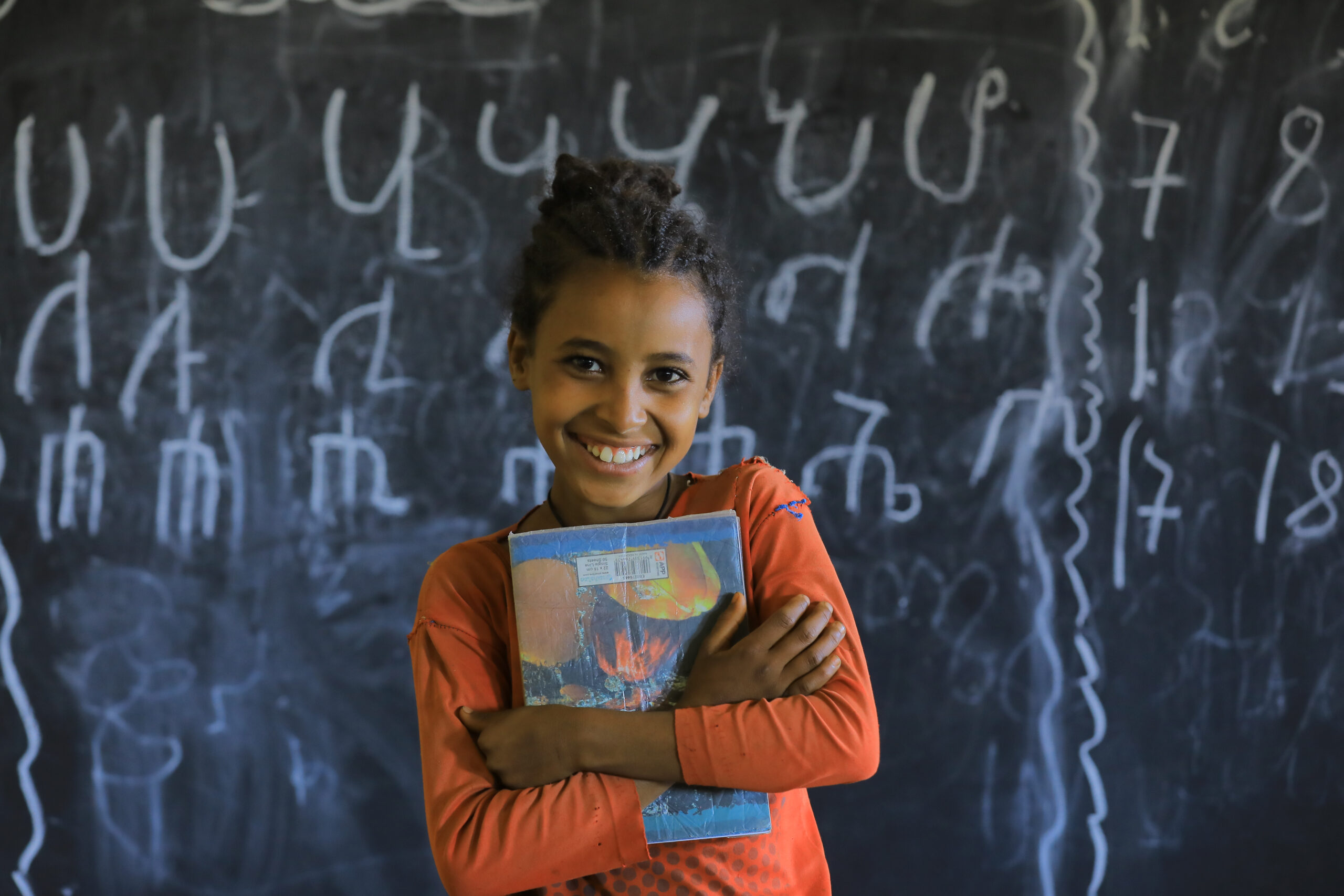 Schoolgirl with her notebooks in a classroom